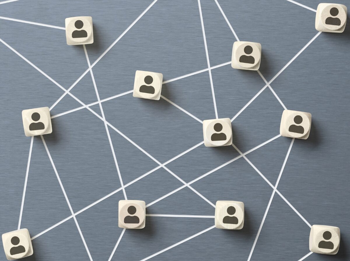About and Join Page Wooden blocks with people icons, linked together by white lines in a network